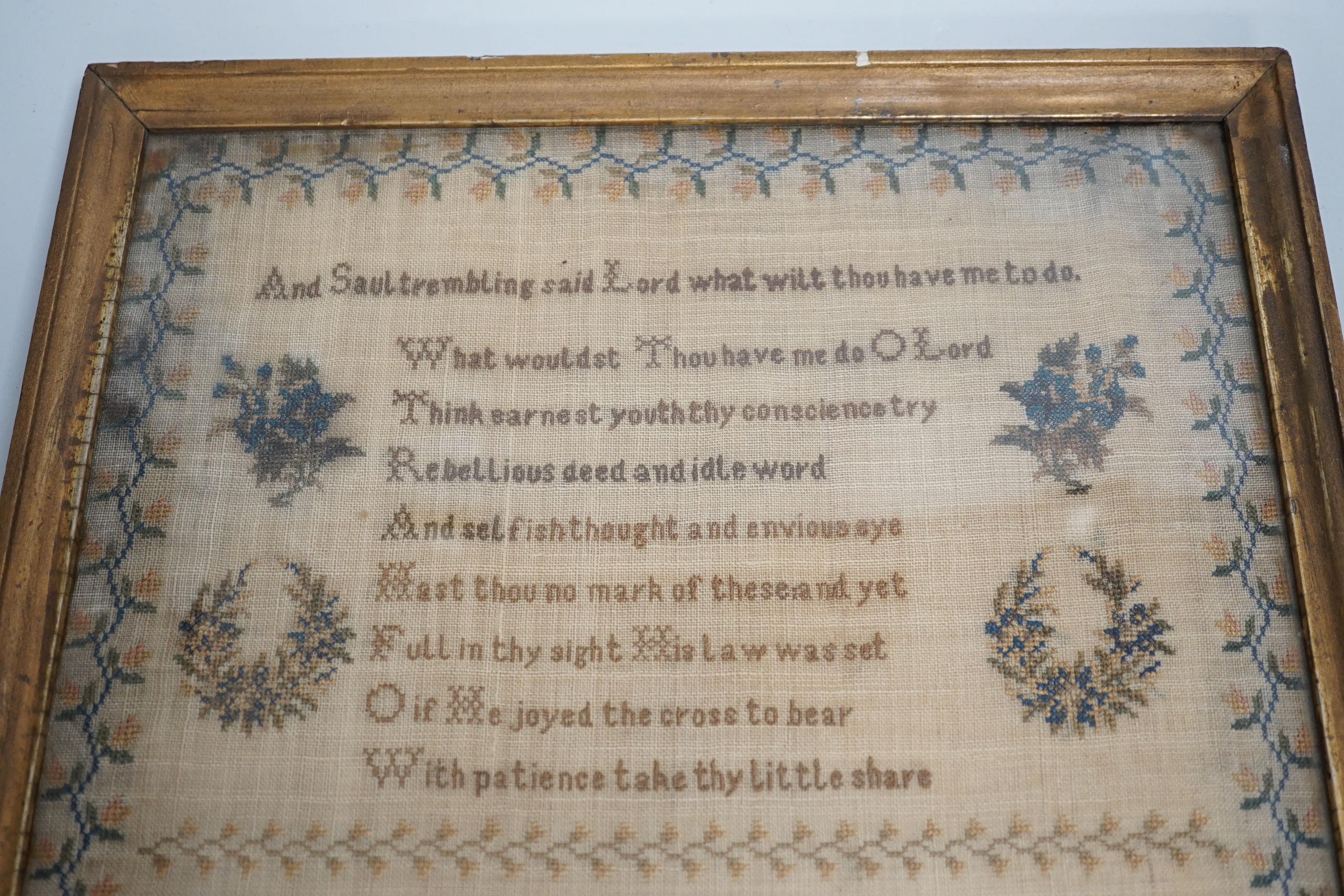 A mid 19th century framed sampler worked by Hannah Clarice, aged 13, 1853, embroidered with a verse and flowers, overall 42cm x 35cm